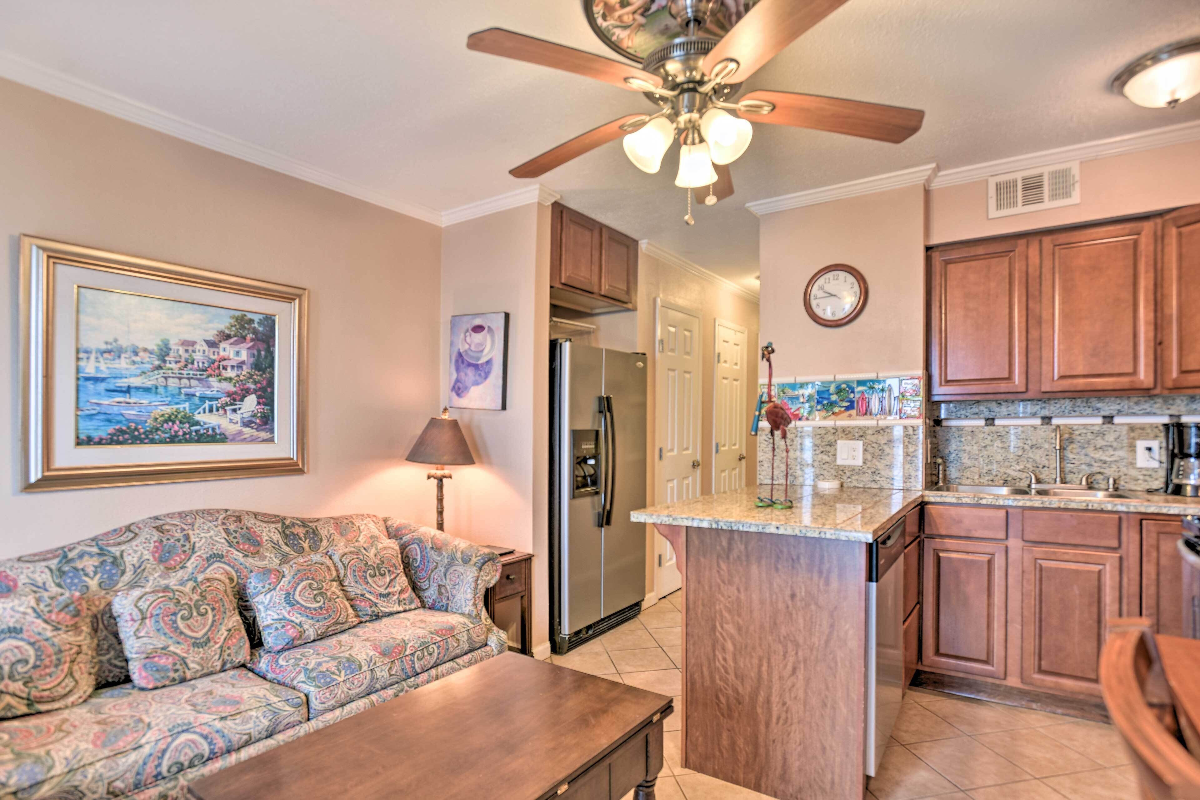 A modern kitchen with a central island, wooden cabinets, and a built-in oven.