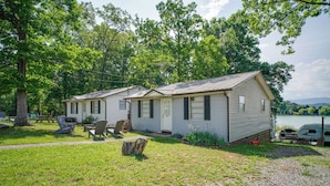 A row of mobile homes with a grassy yard, picnic tables, and a lake view. - Lakefront Cabin in Dandridge w/ Fire Pit & Grill! (Dandridge)