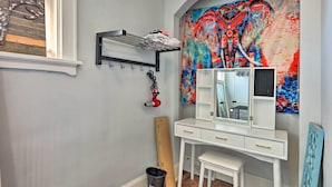 A bathroom with a white vanity, a large mirror, and a colorful abstract painting on the wall. - Pet-friendly Covington Retreat w/ Fenced Yard (Latonia)