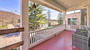 A covered porch with a red wooden floor, white railings, and wicker furniture. - Pet-friendly Covington Retreat w/ Fenced Yard (Latonia)