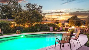 A swimming pool with a green light, surrounded by chairs and tables, with a sunset in the background. - 5 Mi to Dtwn: Austin Gem w/ Pool, Pets Welcome (Austin)
