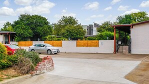 A parking area with a white wall, a wooden fence, and a gated entrance. - 5 Mi to Dtwn: Austin Gem w/ Pool, Pets Welcome (Austin)