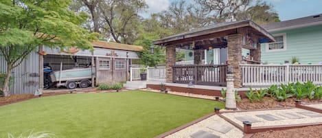 A residential property with a well-maintained lawn, a stone patio, and a fenced backyard.