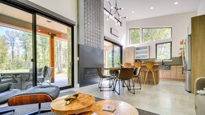 A modern living room with a fireplace, dining area, and kitchen. - Rock Creek Retreat: Creekside Cabin Near Red Lodge (Red Lodge)