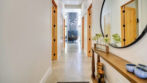 A hallway with wooden doors, a mirror, and a console table with decorative items. - Rock Creek Retreat: Creekside Cabin Near Red Lodge (Red Lodge)