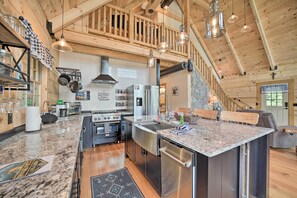 A spacious kitchen with granite countertops, stainless steel appliances, and a wooden ceiling. - Luxe Log Cabin w/ Modern Finishes & Mtn Views (Maggie Valley)