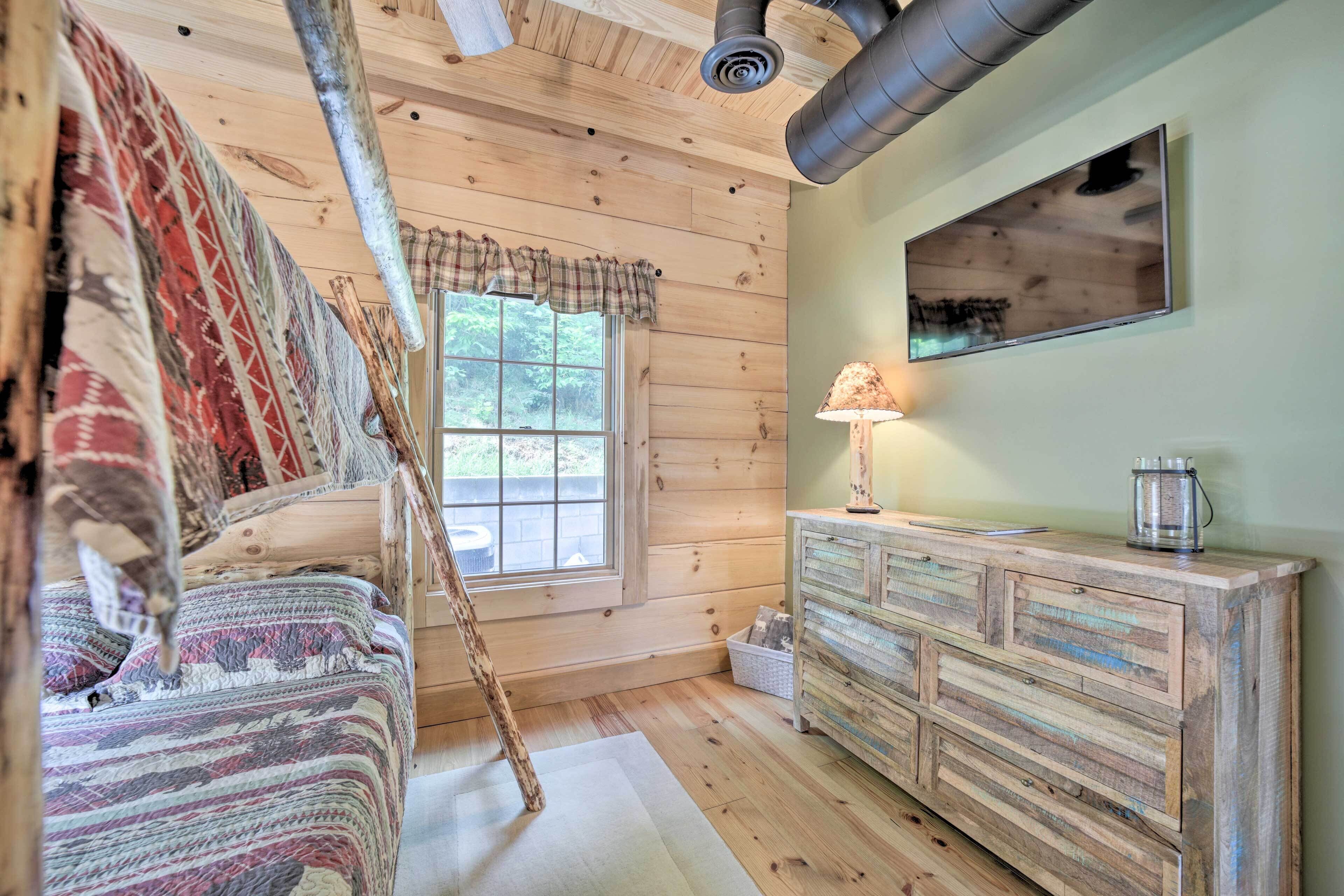Een gezellige kamer met een bed, een dressoir, een raam met gordijnen en een plafondventilator.