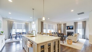 A spacious living area with a large island, a fireplace, and a television. - Near Bethany Beach: Resort-style Home w/ Views (Ocean View)