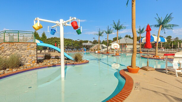 A water park with a pool, slides, and palm trees. - Near Bethany Beach: Resort-style Home w/ Views (Ocean View)