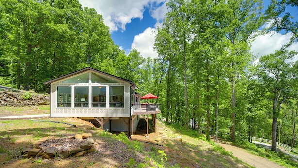 A modern cabin with large windows, a deck, and a red umbrella. - Remote Smoky Mtn Escape w/ Views & Trail Access! (Franklin)