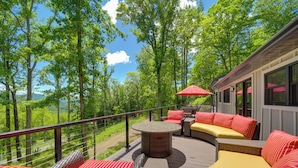 A deck with outdoor furniture, a round table, and a view of a forested area. - Remote Smoky Mtn Escape w/ Views & Trail Access! (Franklin)