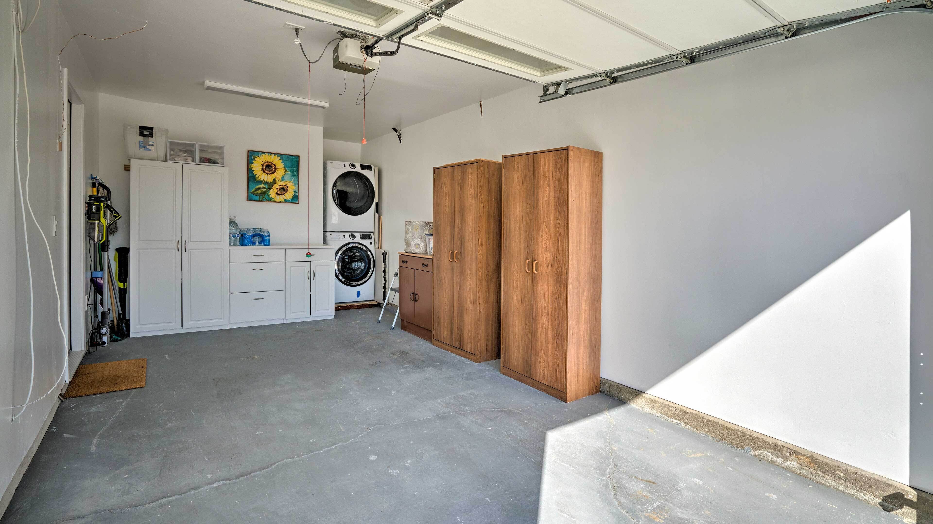 Un cuarto de lavandería con lavadora, secadora y armarios de madera.