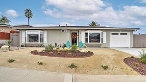 A single-story house with a front yard, a garage, and a palm tree. - San Marcos Home w/ Patio & Grill - Walk to Lake! (San Marcos)