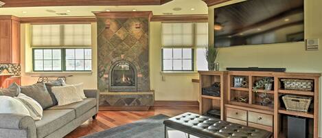Una sala de estar acogedora con chimenea, un televisor de pantalla plana grande y estanterías de madera.
