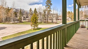 A wooden deck with a view of a residential area, including houses and a mountain in the background. - Skier's Dream: Upscale Condo By Teton Village! (Wilson)