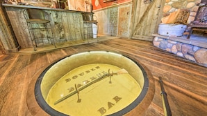 Zona de bar con diseño vintage, que incluye un dardo y una barra de madera.