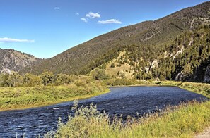 Um rio serpenteando por uma paisagem montanhosa com florestas densas.