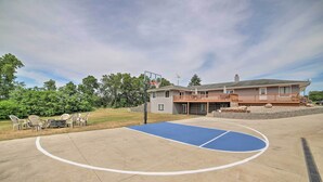 En basketplan med ett hus i bakgrunden.