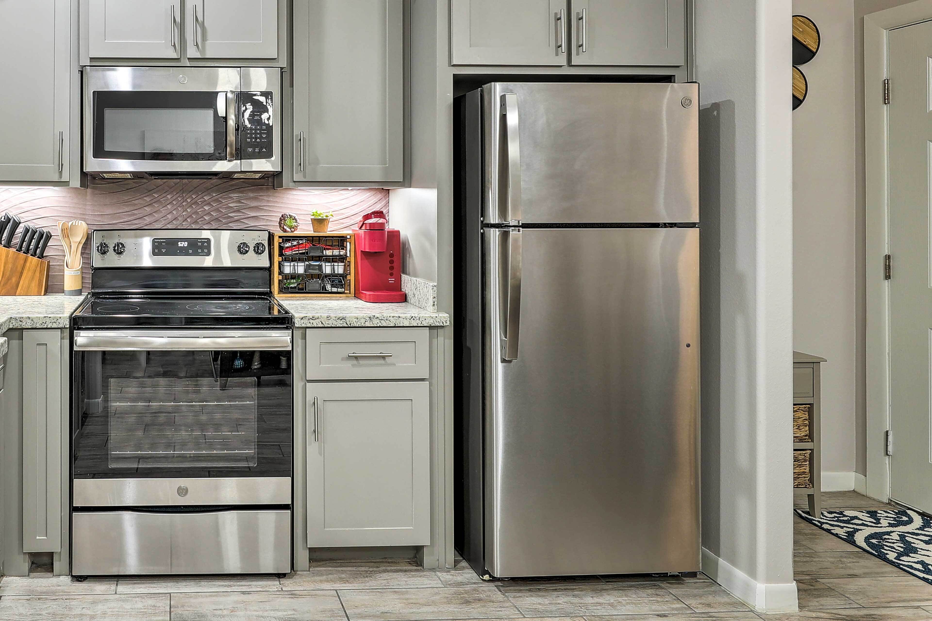 A kitchen with stainless steel appliances, including a microwave, oven, and refrigerator.