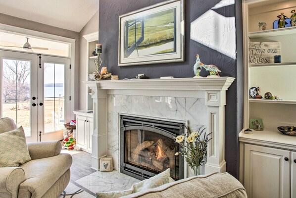 A living room with a fireplace, a sofa, a coffee table, and a bookshelf.