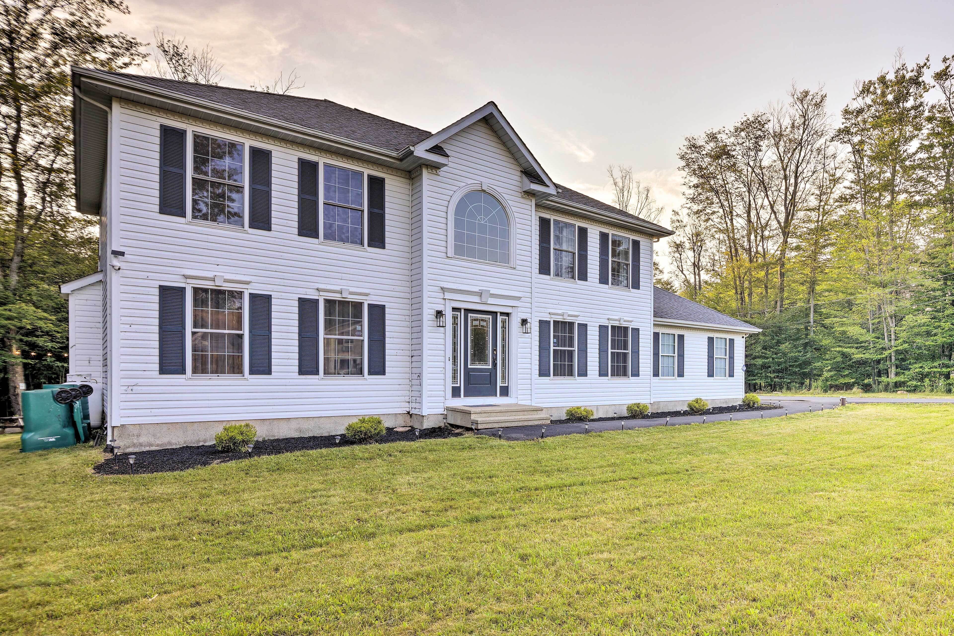 A two-story house with a front porch, a garage, and a well-maintained lawn.