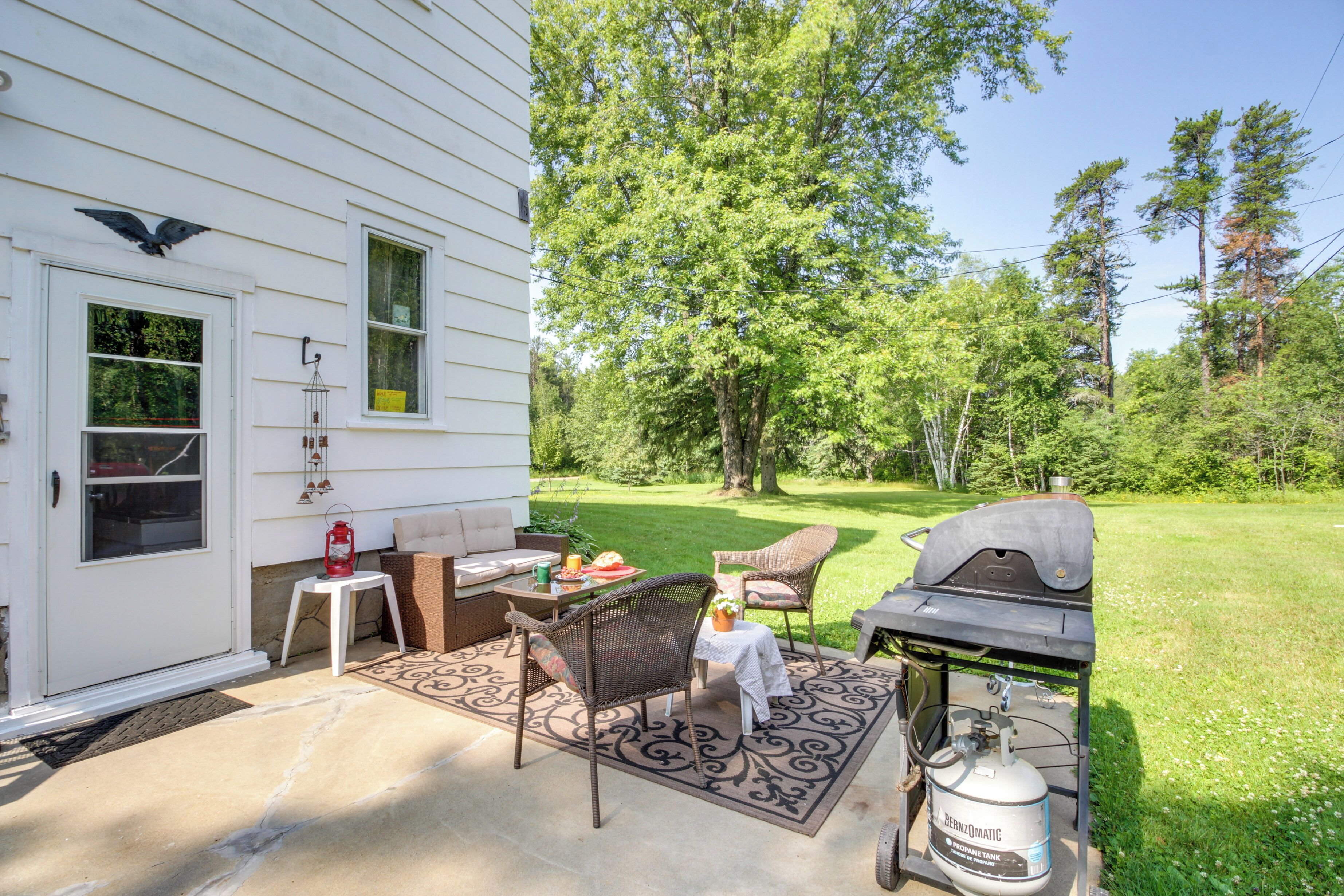 A patio with outdoor furniture, a grill, and a propane tank.