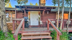 A rustic cabin with a wooden porch, a grill, and a stone wall. - 'moose Park Lodge' Charming Walden Retreat! (Walden)