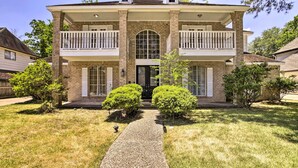 A two-story house with a front porch, a central entrance, and a small front yard with a gravel path. - Spacious Houston Getaway ~ 23 Mi to Downtown! (Houston)