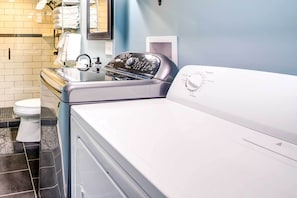 A laundry room with a front-loading washer and dryer, a tiled backsplash, and a toilet. - Waterfront Florence Home w/ Private Dock! (Florence)