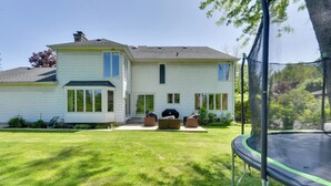 A two-story house with a front porch, a trampoline, and a well-maintained lawn. - Spacious Buffalo Brick Home w/ Backyard! (Buffalo)