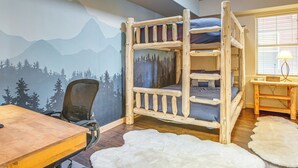 A bunk bed with a forest mural, a desk, a chair, and a lamp. - Condo Near Winter Park Resort + Steps From Shuttle (Fraser)