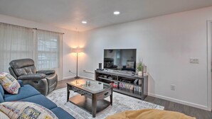 A modern living room with a leather recliner, a glass coffee table, a flat-screen TV, and a bookshelf. - Pet-friendly PNW Home, 1 Mi to Rockaway Beach (Rockaway Beach)