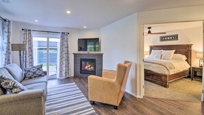 A modern bedroom with a large bed, a fireplace, a sofa, and a chair. - Updated Port Orchard Home, Walk to Waterfront (Port Orchard)