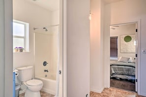 Een badkamer met toilet, douche en bad.