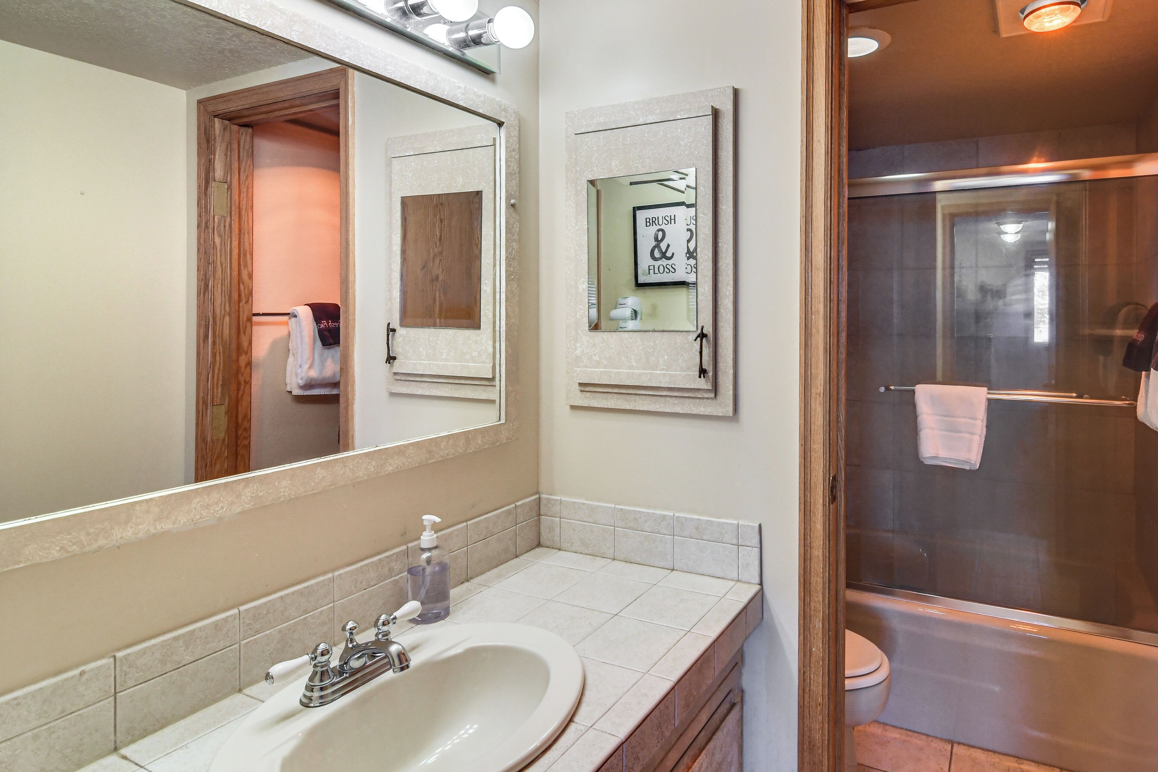 Une salle de bain avec un lavabo, un miroir et une douche.