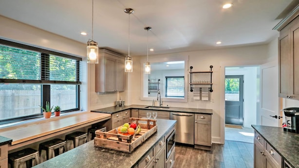 A modern kitchen with a central island, stainless steel appliances, and pendant lighting. - Updated Downtown Red Bank Home 5 Mi to Beach! (Red Bank)