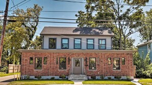 A two-story brick house with a front porch, a garage, and a well-maintained lawn. - Updated Downtown Red Bank Home 5 Mi to Beach! (Red Bank)