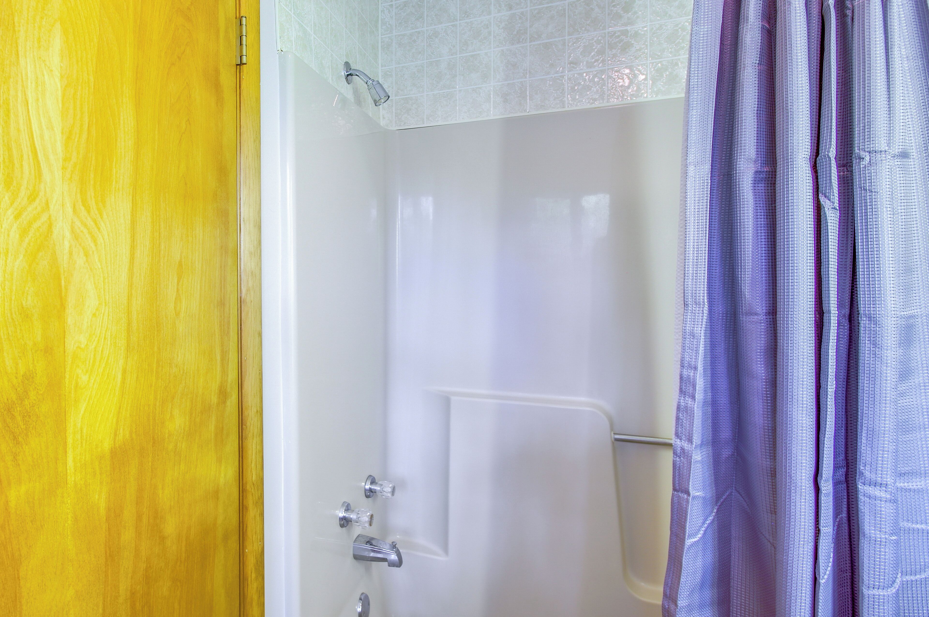 A bathroom with a shower, a toilet, and a sink.