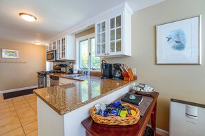 A modern kitchen with granite countertops, white cabinetry, and a large island. - Peaceful Waterfront Apt w/ Deck, 22 Mi to Portland (Freeport)