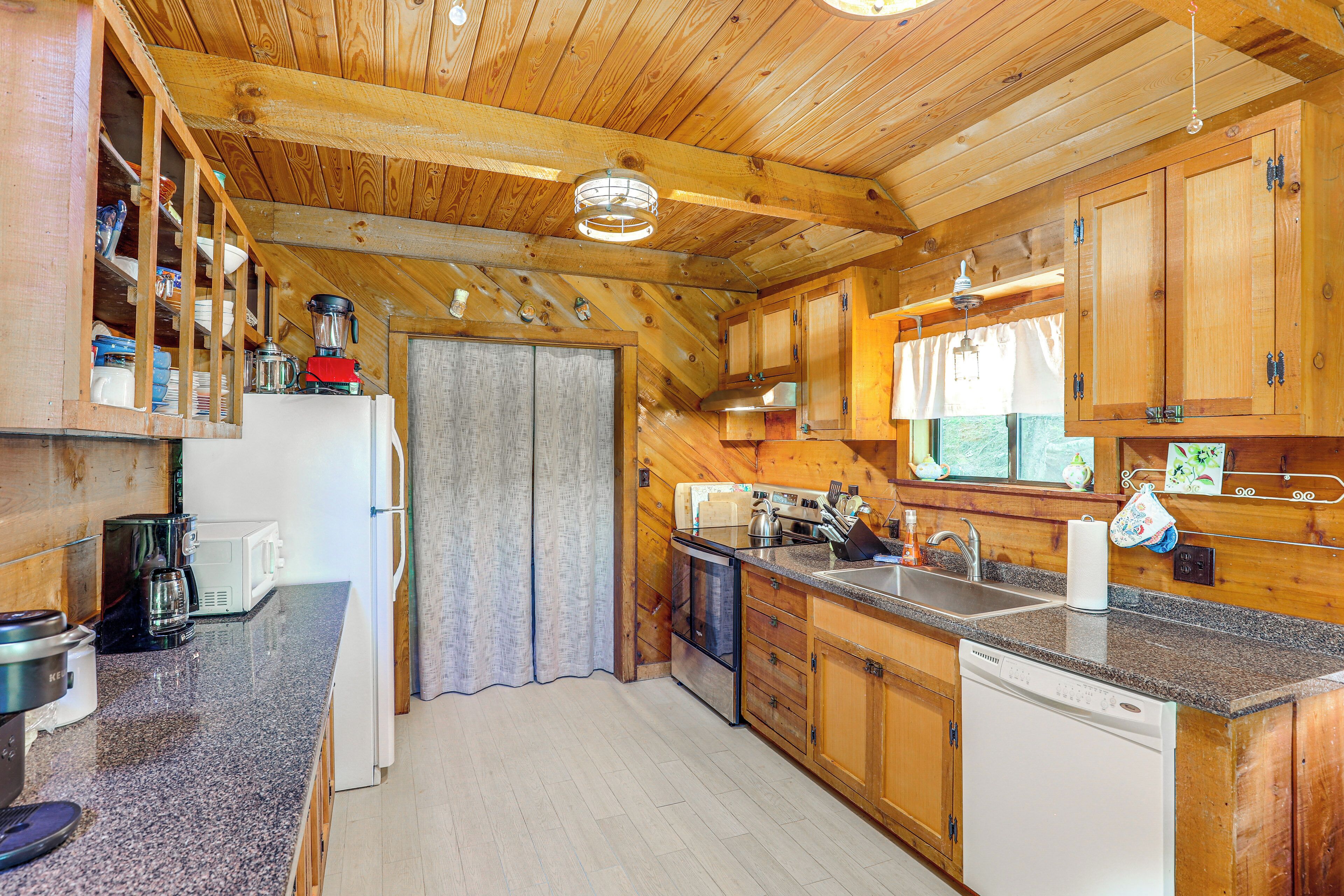 Une cuisine avec des meubles en bois, un plan de travail en granit et des appareils électroménagers modernes.