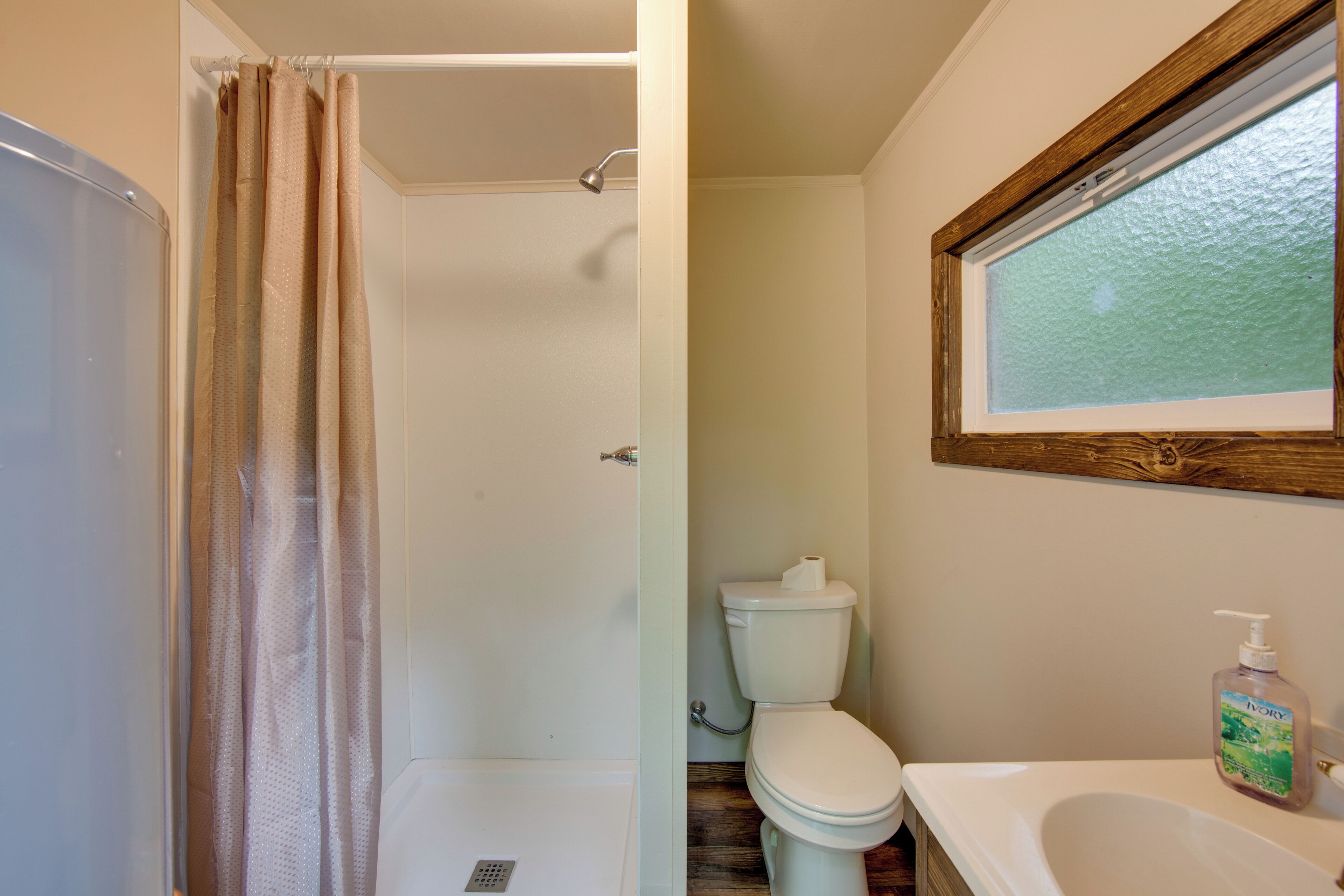 Une salle de bain avec douche, toilettes et lavabo.