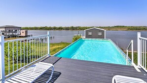 A swimming pool with a deck, a small building, and a view of a river. - Waterfront Sargent House w/ Sparkling Pool! (Bay City)