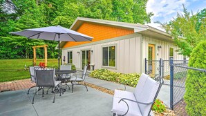A modern house with a patio area featuring outdoor furniture and a swing set.