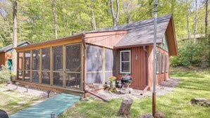A wooden cabin with a large glass extension, a wooden deck, and a barbecue grill. - Dock & Lake Access! St Germain Getaway (St Germain)