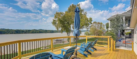 Una terraza con mobiliario exterior y vista a un lago.