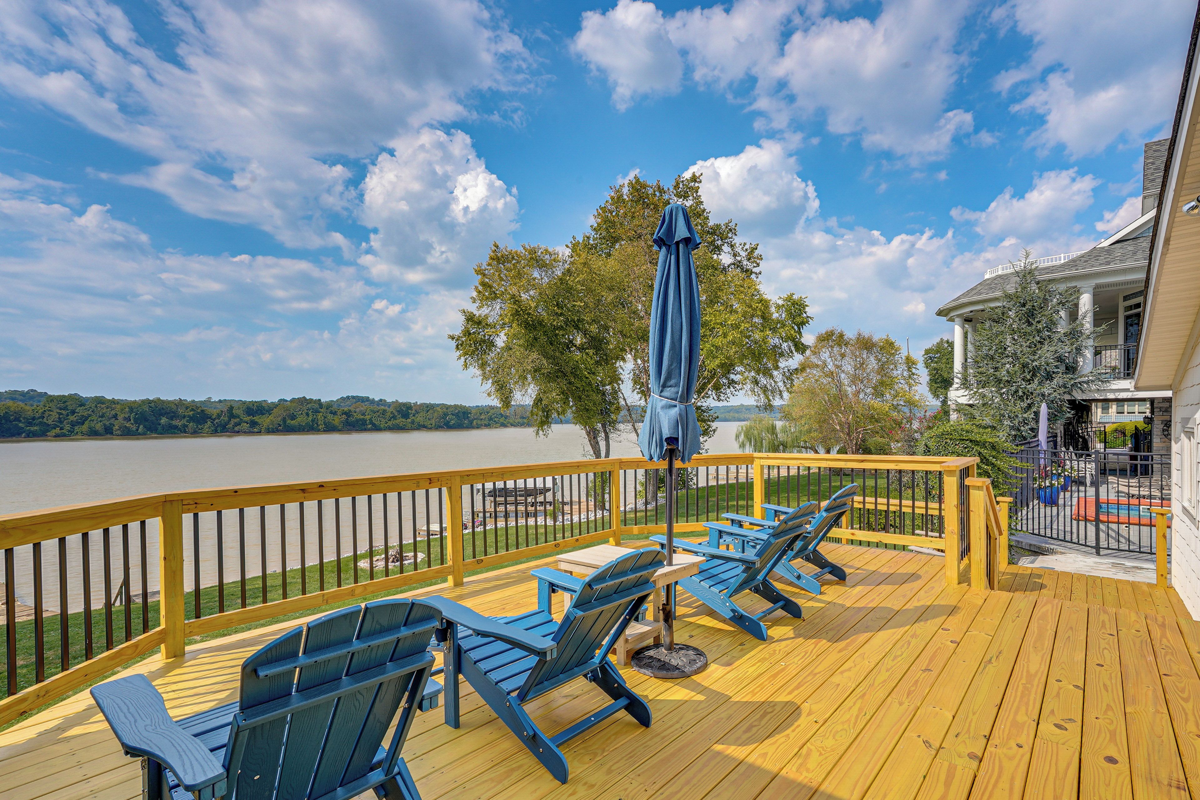 Una terraza con mobiliario exterior y vista a un lago.