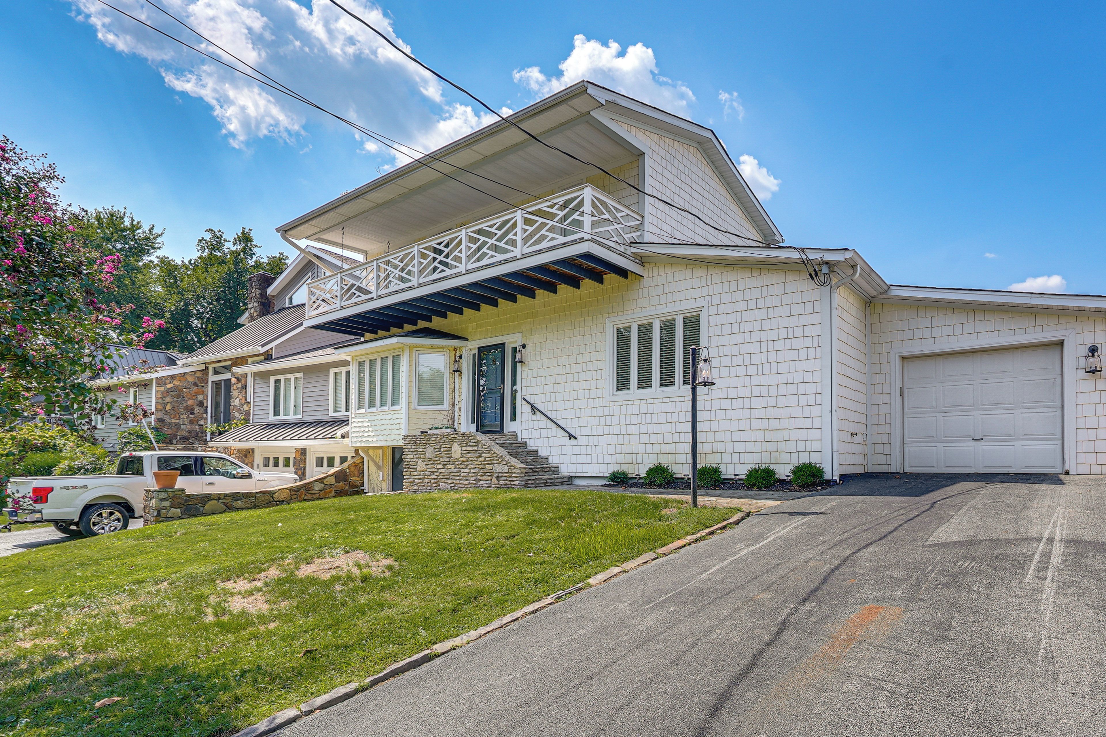A two-story house with a stone facade, a garage, and a well-maintained lawn.