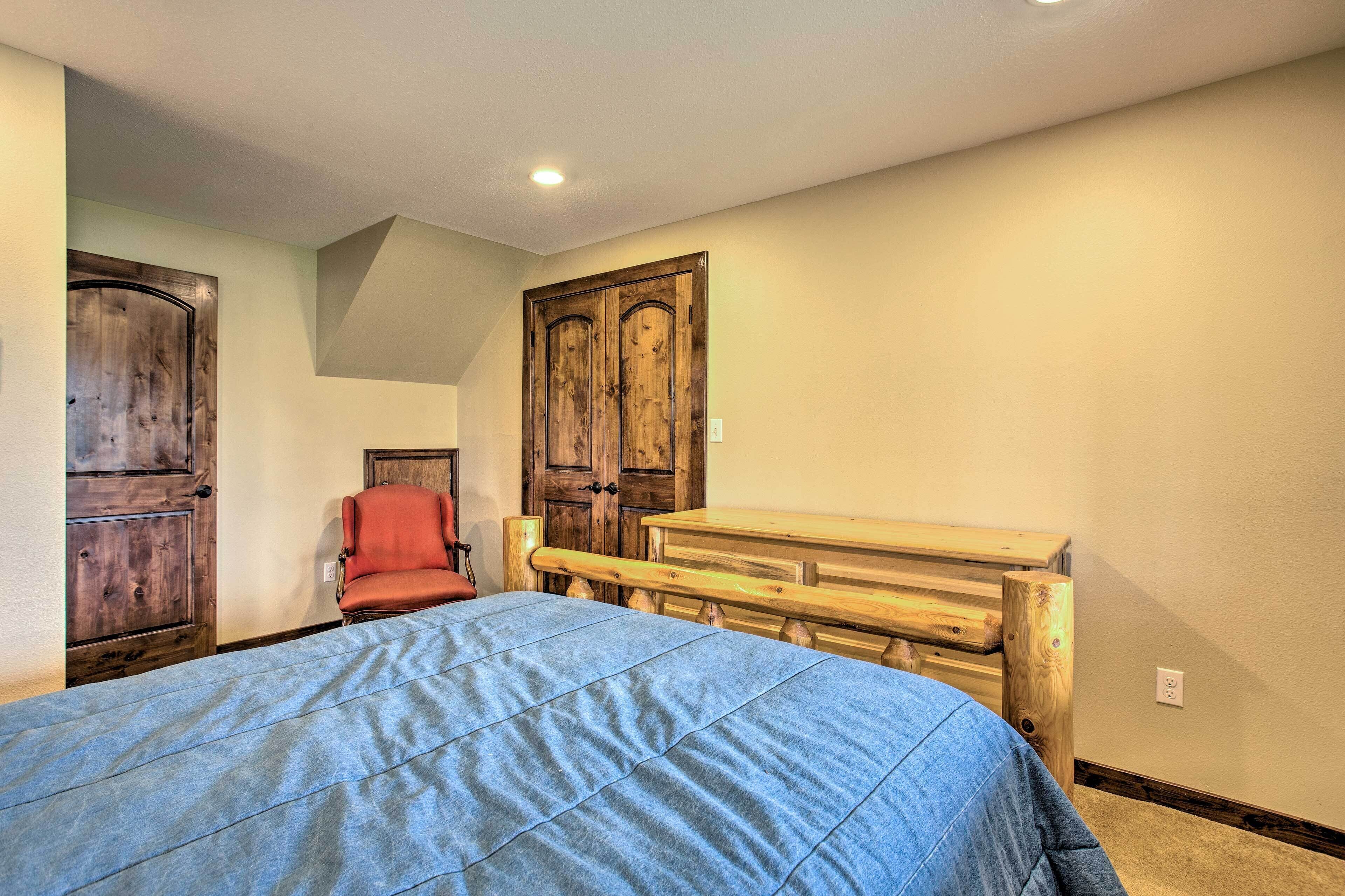 Un dormitorio con una cama, un banco de madera y dos puertas.