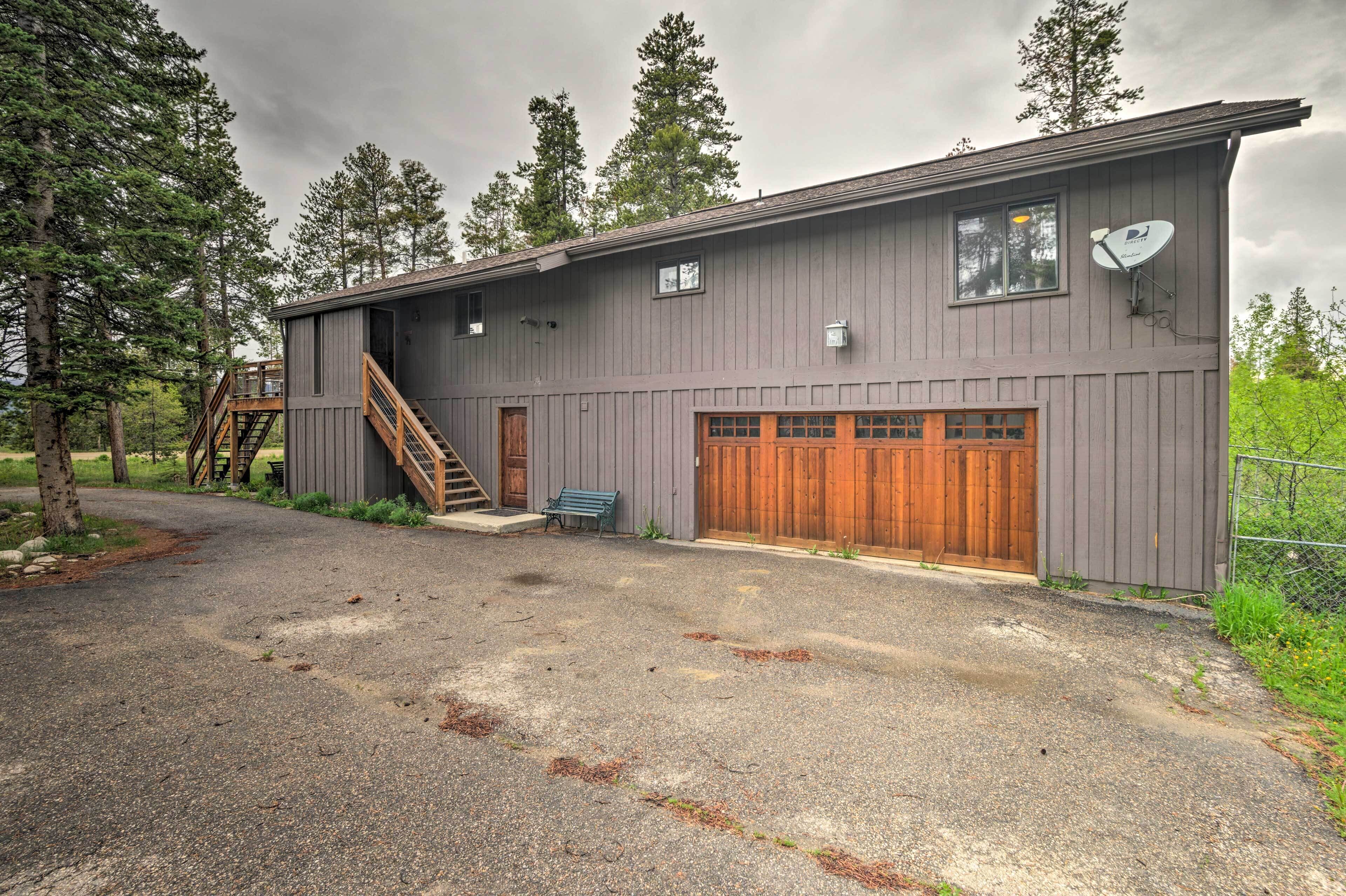 A two-story building with a wooden deck, a garage, and a satellite dish.