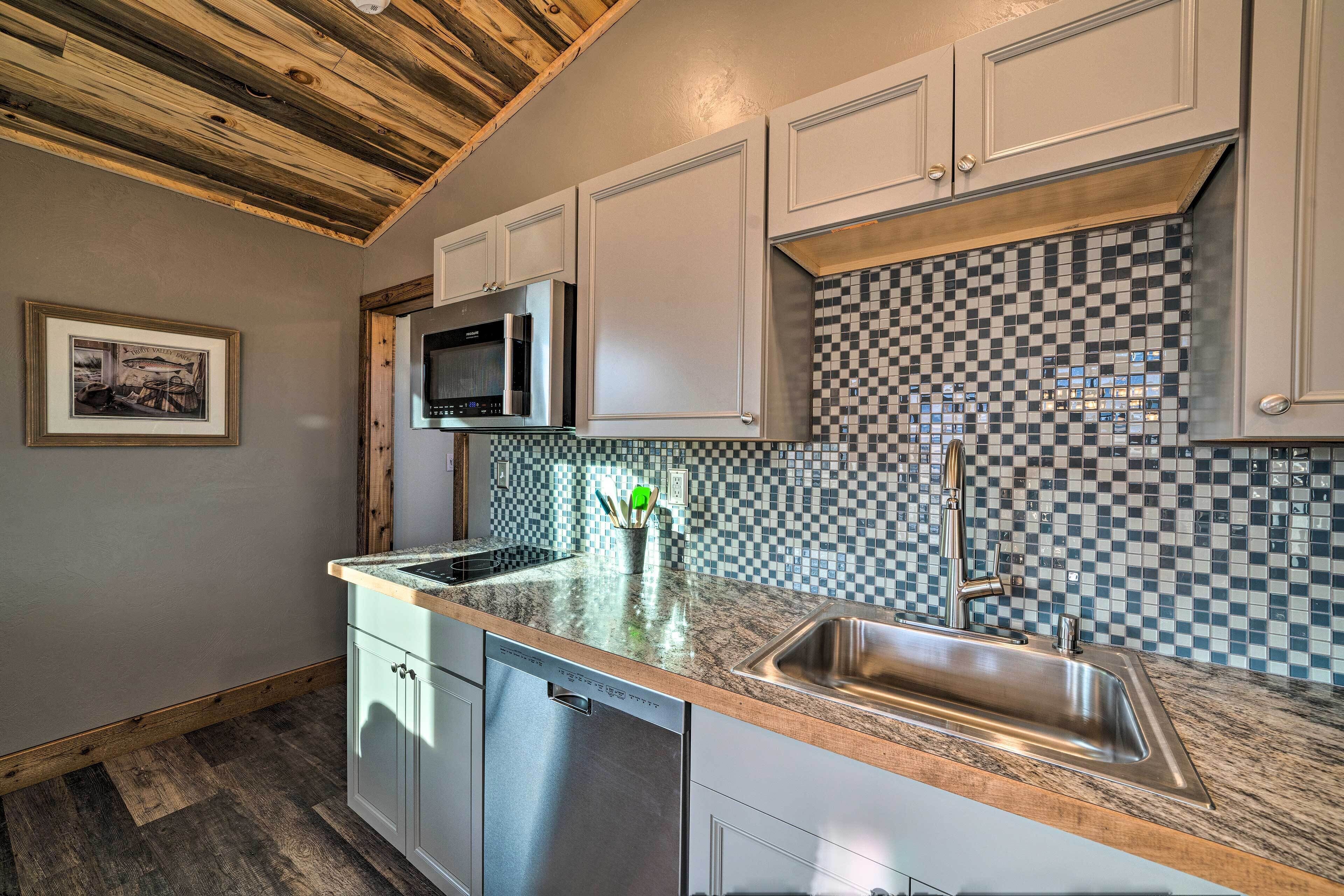 A kitchen with a checkered backsplash, stainless steel appliances, and a dishwasher.